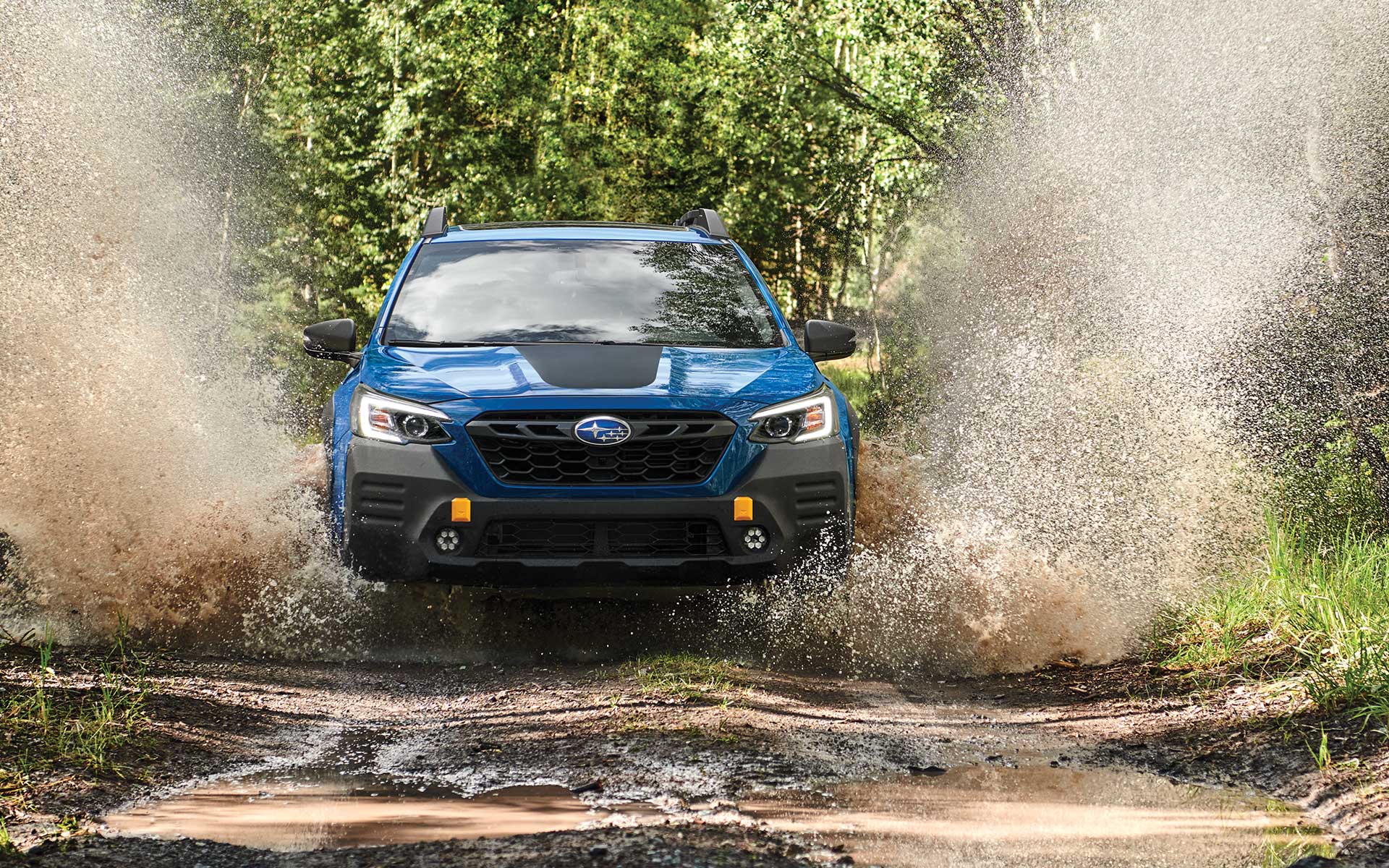 2022 Subaru Outback Wilderness driving through mud.