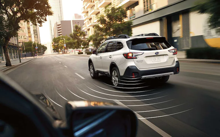 A 2022 Subaru Outback driving on a city street.